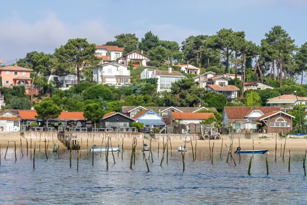 Cabanes ostréicoles et maisons du Bassin d'Arcachon Maisons et cabanes ostréicoles avec pignots sur une plage ensoleillée du Bassin d'Arcachon.